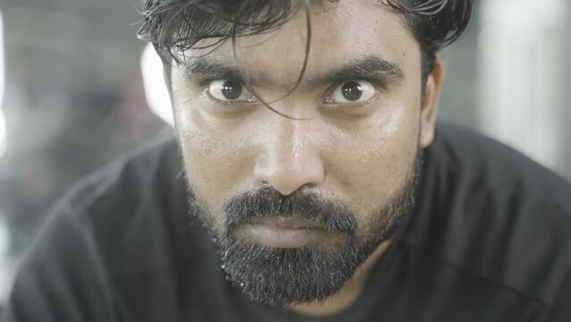 Close up head shot of serous athlete rising head by looking camera at gym - concept of inspirational, motivation and fitness