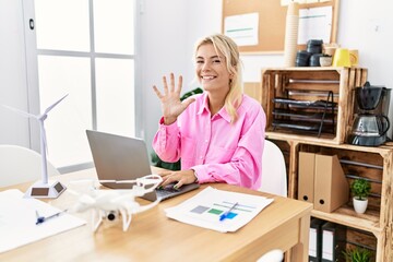 Young caucasian woman working at the office showing and pointing up with fingers number five while smiling confident and happy.
