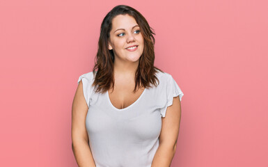 Young plus size woman wearing casual white t shirt smiling looking to the side and staring away thinking.