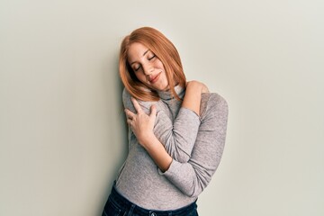 Young irish woman wearing casual clothes hugging oneself happy and positive, smiling confident....