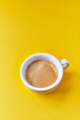  One cup of coffee with milk over yellow background