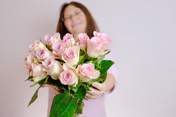 close-up of bouquet of white, pink roses, in hands of adult woman, brought flowers on date with girlfriend, boyfriend, gives to mom, concept of mother's, Valentine's day, birthday, christmas gift