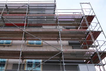 construction site, metal assembly scaffolding near the walls of a new multi-storey building, construction site with materials for the construction of buildings in the city