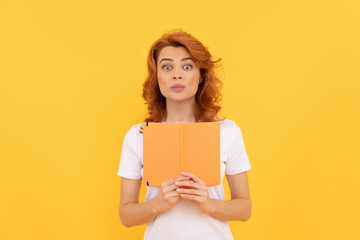 surprised girl hold copybook on yellow background, knowledge