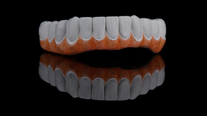 dental zircon to create a prosthesis of the lower jaw with a primary painted gum on a black...