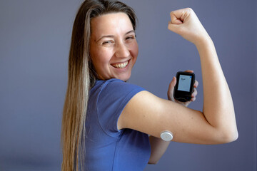 Girl with a flash glucose monitor, patch on her hand, making power gesture