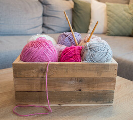 colorful woolen balls in a wooden box with bamboo knitting needles