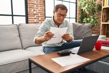 Middle age man working using laptop at home