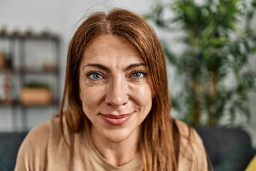 Obraz premium Middle age caucasian woman smiling happy sitting on the sofa at home.