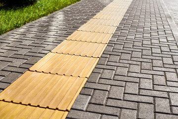 Yellow tactile paving on walkway, tactile ground surface indicators for blind and visually impaired - obrazy, fototapety, plakaty