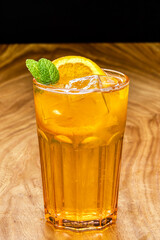 Orange cocktail garnished with green leaves