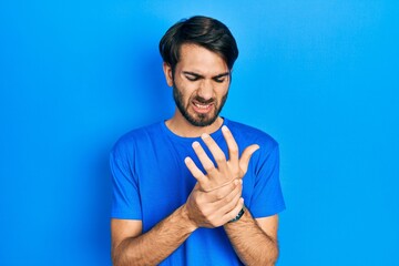 Young hispanic man wearing casual clothes suffering pain on hands and fingers, arthritis inflammation