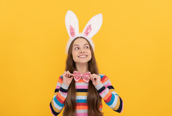 happy easter teen child in bunny ears and bow tie on yellow background