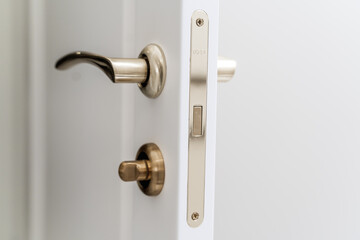 Stylish bronze door handle and lock on a white new interior door