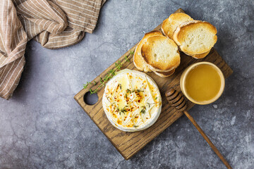 Baked camembert with toasts, honey and thyme