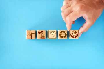 wooden cubes with icons - renewable energy, co2 emissions reduction, green production, waste...