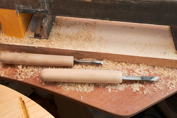 Carpenter wood chisel tool with carving on old weathered wooden workbench