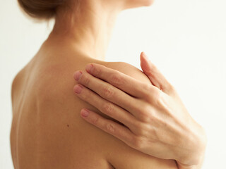 woman's shoulder with a hand on it, on a white background, without a face