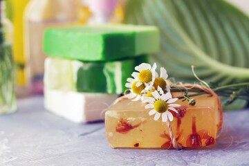 Natural soap, skin care products, oils, tinctures and chamomile flowers on the table, the concept of cleanliness, healthy lifestyle, body care