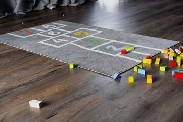 Mobile game space for kids at home. Children’s number jump carpet and colourful building blocks...