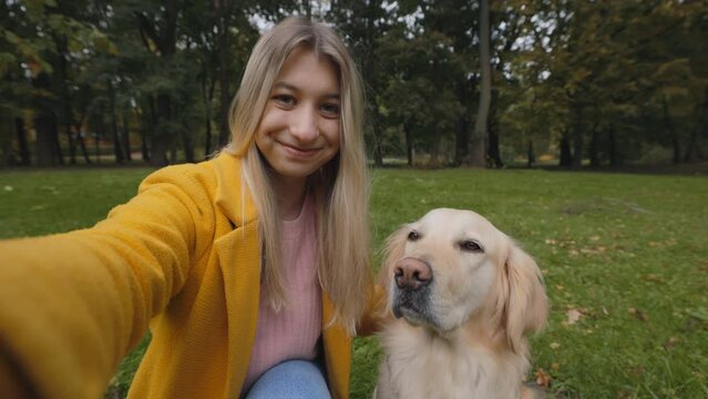 Happy woman filming video while petting her french retriever