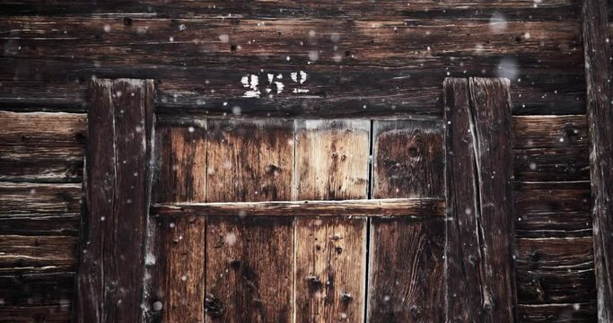 Flocons de neige au ralenti devant une porte en bois