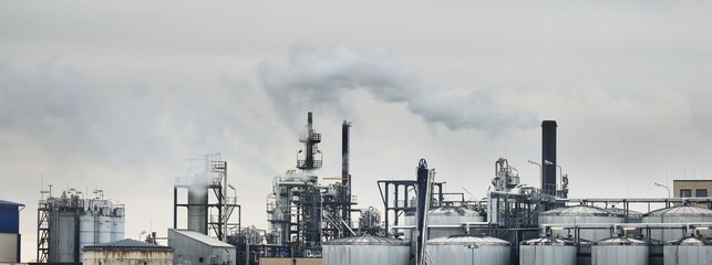 Chemical factory on a hazy day  silos, factory pipe, smoke. Dark panoramic urban cityscape. Industry, business, technology. fuel and power generation, ecological issues, environmental damage © Alex Stemmer