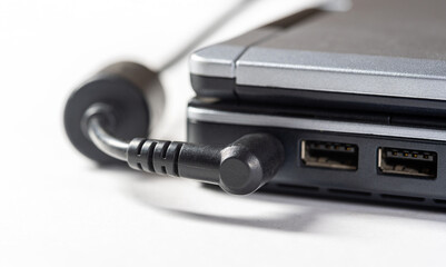Plugging in a laptop power supply adapter, charger cable plug, object detail, closeup. Electricity,...
