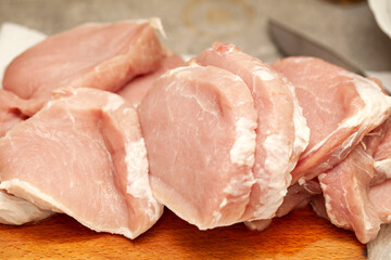 Lots of uncooked fresh juicy raw fat pork chop meat pieces, freshly cut up, food, object closeup,...