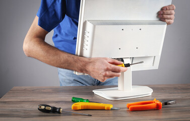 Electrician engineer repairing computer monitor.