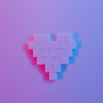 Pixel Heart made from sugar cubes on fluorescent color background. Minimal creative Love or Valentines concept.Flat lay.