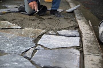 Worker installing concrete to build stony pavement