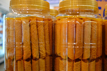 Close up of love letters, traditional Peranakan snacks in plastic jars sold in supermarket. These...