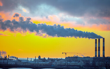 Obraz premium Smoke from industrial chimneys and a heavenly landscape at sunset.