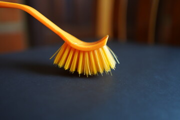 New yellow cleaning brush on black floor.