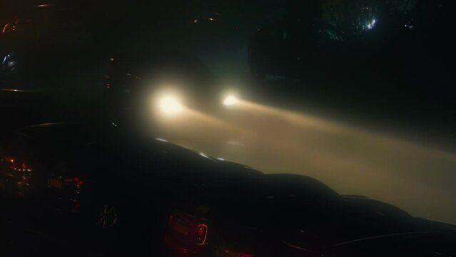 Cars Drive Past In Thick Mist At Night