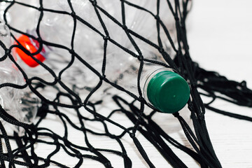 Black string bag with plastic bottles, ecology concept.