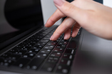 Woman typing on laptop keyboard, office worker