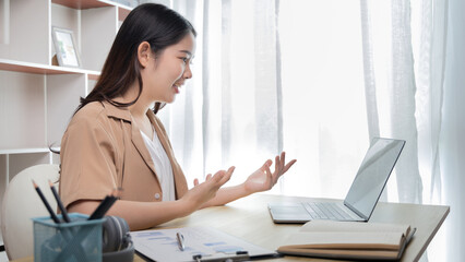 Woman greeting colleague using laptop video chat and greeting with cheerful gesture , Freelancers work or learn in private rooms at home, Online communication, VDO Call ,Home lifestyle.