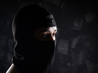 Portrait of a girl in a black balaclava and a black bra.