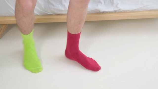 Legs of a dancing man in socks of mismatched different colors. The concept of individuality, originality