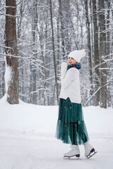 Portrait of young Caucasian woman dressed up white sweater, knitted hat with pompom, fluffy...