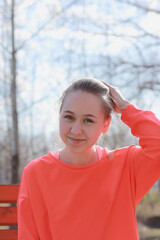 A girl in sports clothes walking in the park sat down on a bench