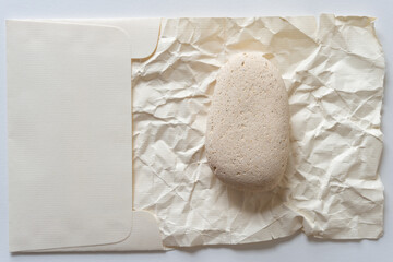 stone on crumpled paper inside a fancy envelope