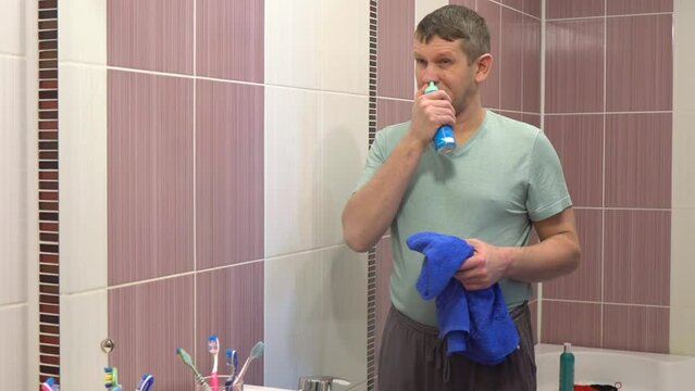 The man washes his nose with a special spray.  A man does a medical procedure