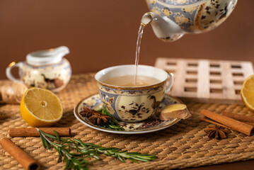 Freshly Brewed Herbal Tea with Ginger and Lemon is Poured from the Kettle into a Cup. Healthy Lifestyle Concept