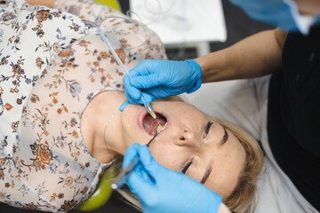 Doctor giving painkiller injection to woman patient using  dental computer anesthesia machine