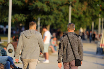 Dwóch mężczyzn spaceruje w parku we Wrocławiu.