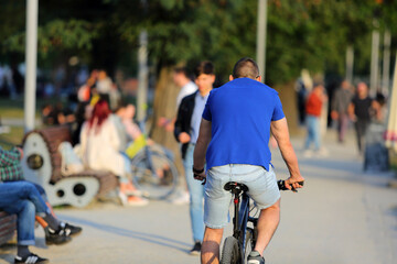 Mężczyzna jedzie rowerem w parku we Wrocławiu.