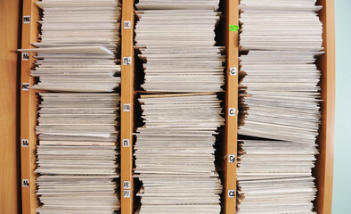 Piles of files Multiple rows of filing cabinets in an office or medical establishment, overflowing...